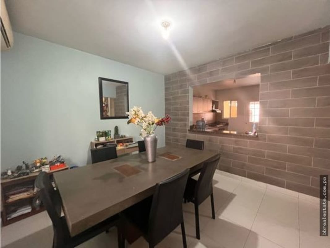 Dining room with brick accent wall and direct kitchen pass-through PH Quintas de Versalles Panama