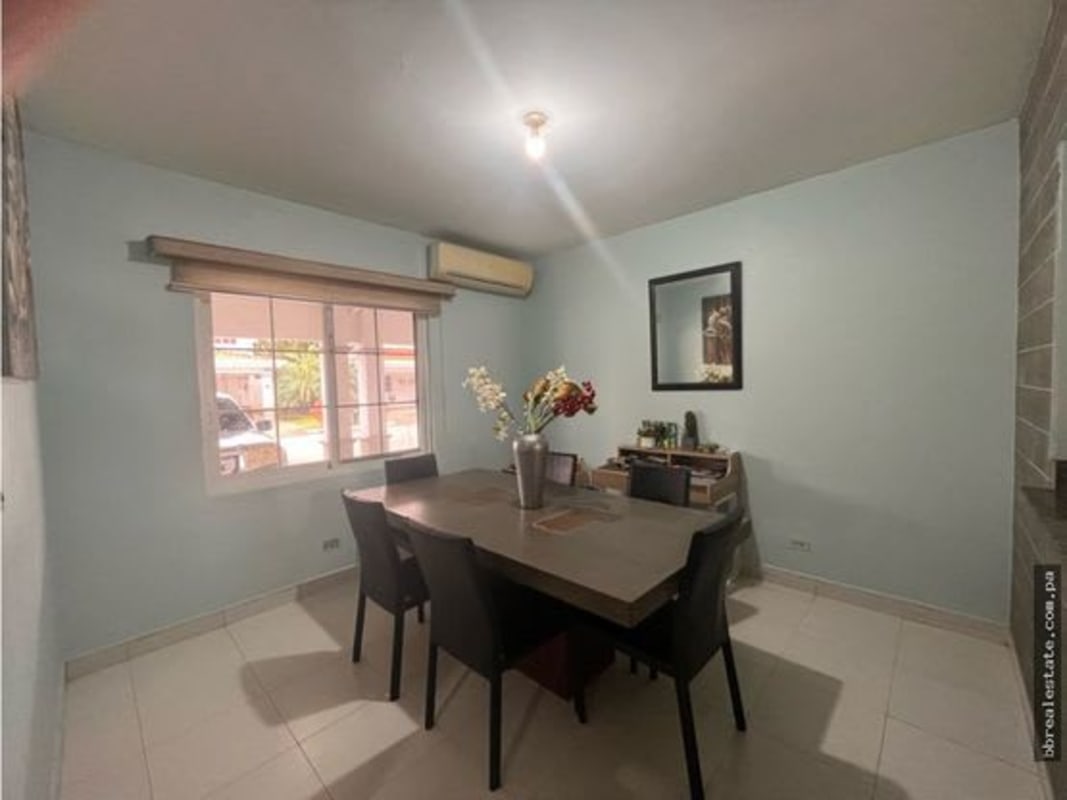 Contemporary dining room with natural light, large window, blue accent wall in house for sale PH Quintas de Versalles Panama City