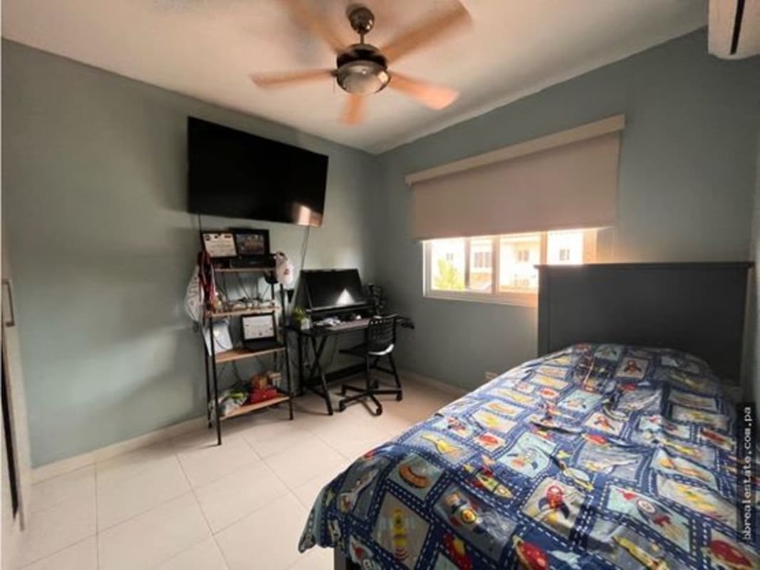 Bedroom with workspace, single bed, AC, fan, and shelving PH Quintas de Versalles Panama