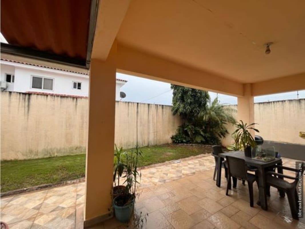 Covered exterior patio area with tiled floor, dining space, and garden in Costa Sur Panama
