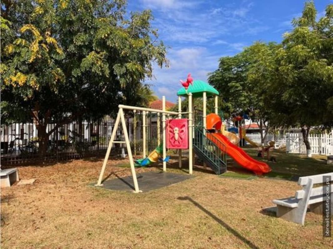 Colorful children's playground with slides, swings and greenery in gated community Costa Sur Panama