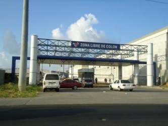 Secure gated entrance to Colón Free Zone with vehicles and checkpoint booth in Panama