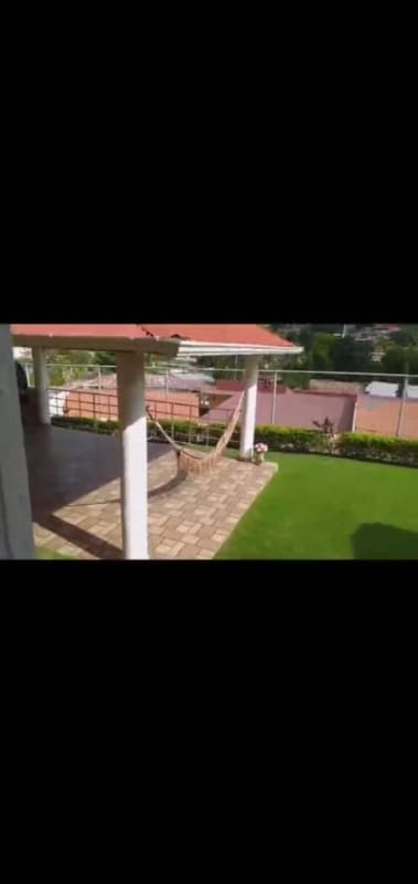 Backyard with garden, patio area, green lawn surrounded by wall in Alto del Bosque house Panama