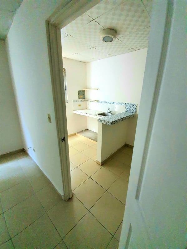 Compact minimalist kitchen with tiled counter and small sink in rental studio Villa Cáceres Betania Panama City