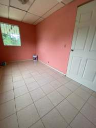 Bedroom with pink walls tiled floor window bars house Fuente del Chase La Chorrera