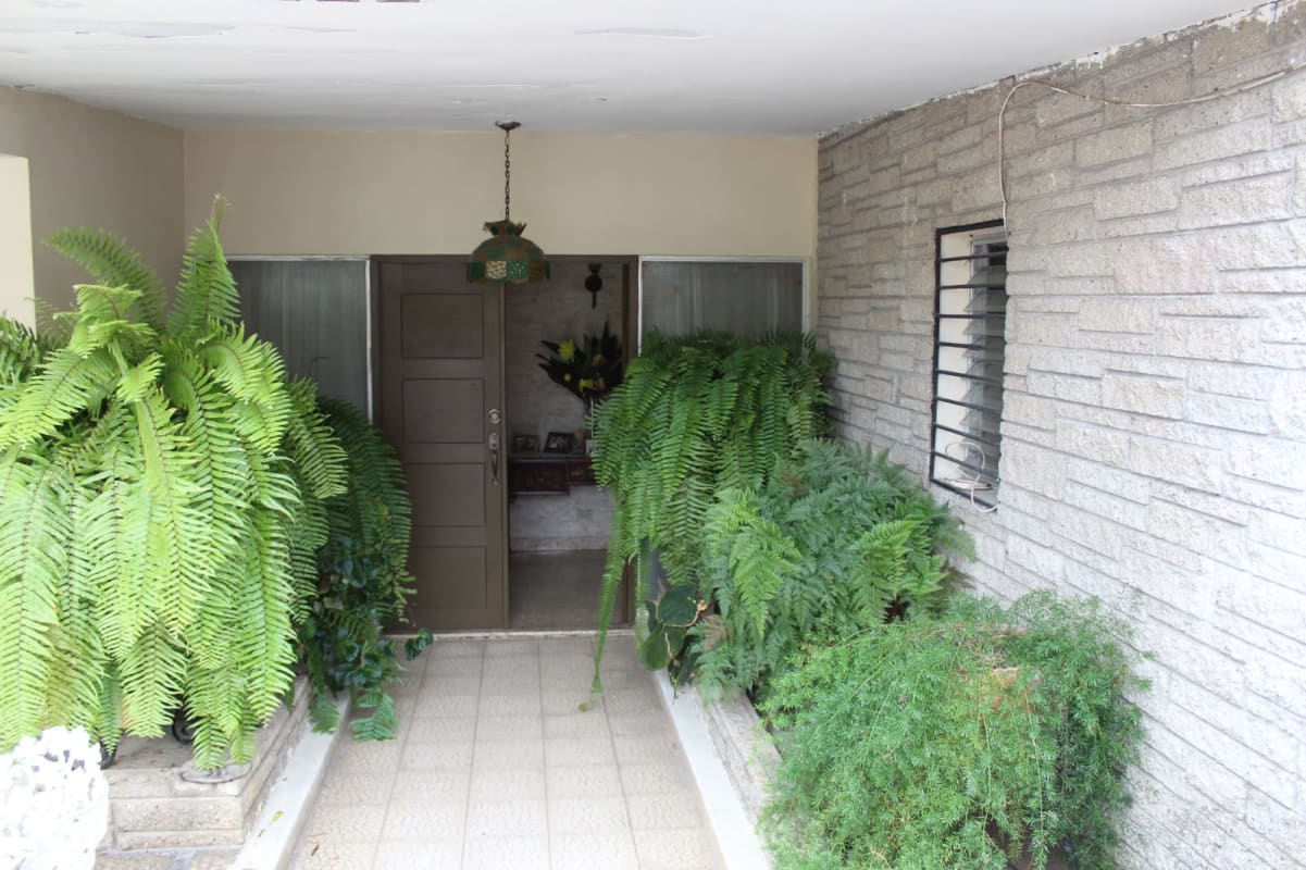 Home entry hall with flower arrangements, wooden bench and art in Las Cumbres Panama