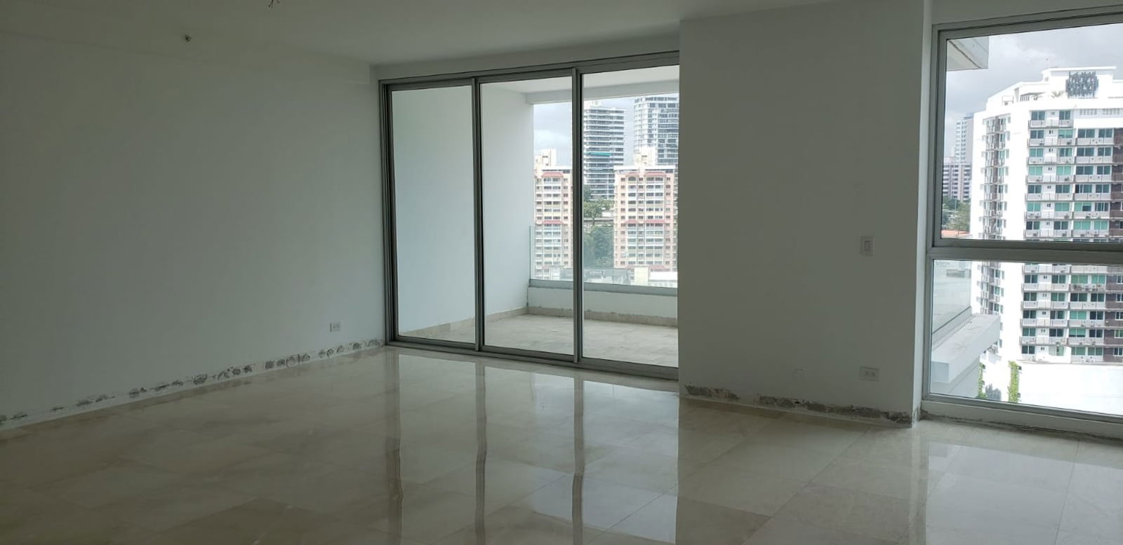 Bright living room with floor-to-ceiling windows and panoramic skyline view PH Bella Vista SkyTower Panama City