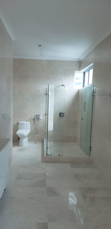 Spacious modern bathroom with marble tiles, glass shower at PH Bella Vista SkyTower Panama City