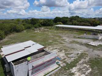 Wide aerial of green open land with warehouse and structures Penonomé Coclé Panama