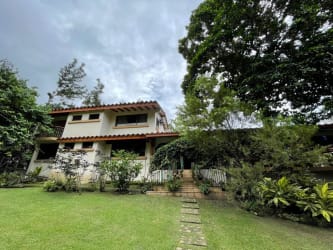 Two-story Mediterranean house with terracotta roof, lush palm gardens in El Valle Coclé Panama