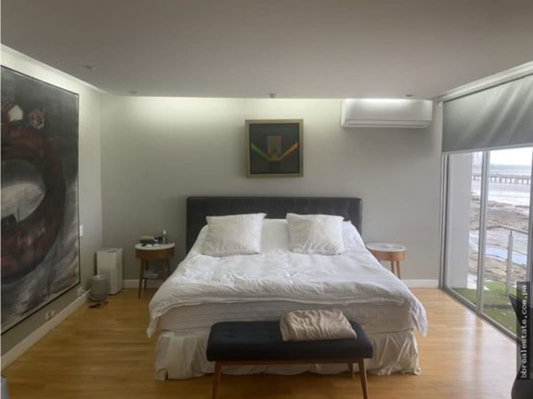 Modern bedroom with large window and ocean view in PH Las Llamas apartment Coco del Mar Panama City