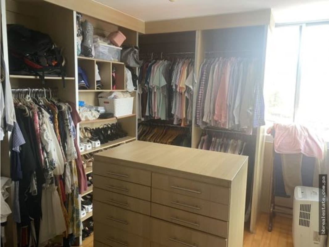 Spacious walk-in closet with open shelves and window in PH Las Llamas apartment Panama