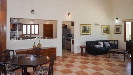 Open living dining room with checkered tile, wood furniture in mountain residence Panama