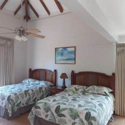 Bedroom with double beds, vaulted ceiling, tropical decor in Playa Blanca house
