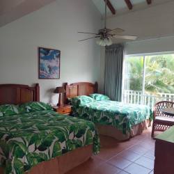 Guest bedroom with tropical bedding, balcony view in Playa Blanca beach property
