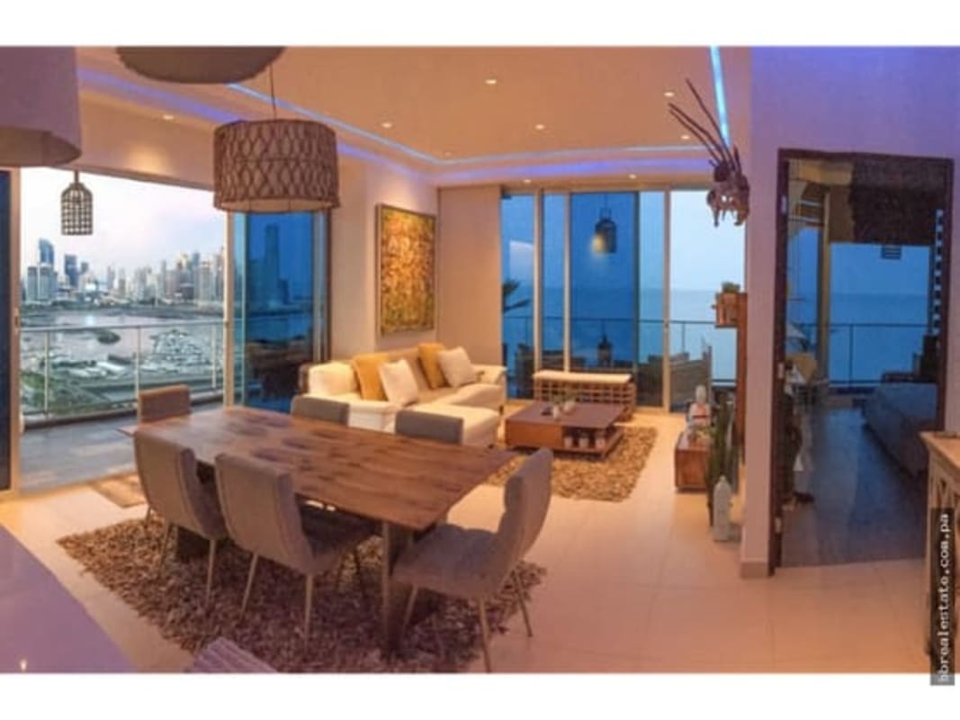 Coastal style bedroom with balcony, large glass doors, overlooking ocean and marina.