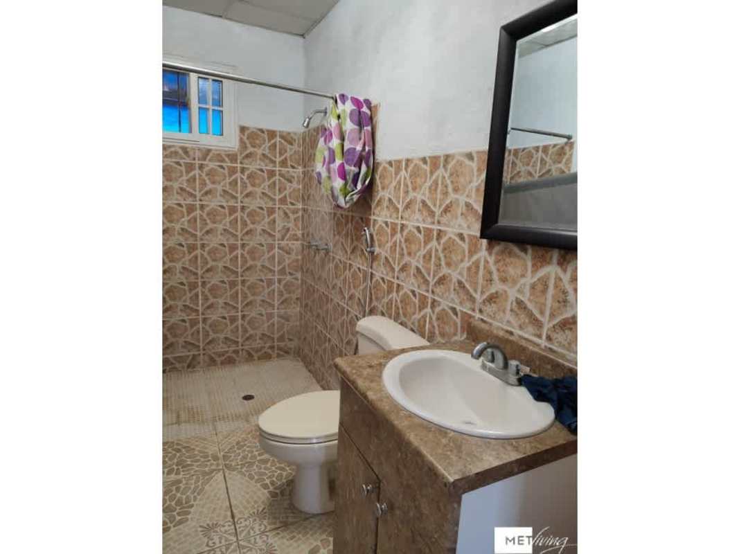 Bathroom with beige tiles, sink, toilet, mirror countryside property in Utive Pacora Panama