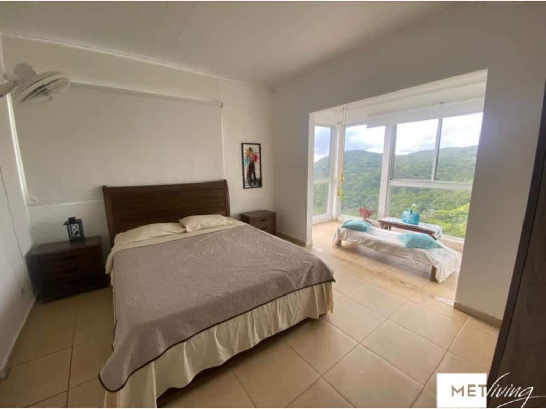 Modern bedroom featuring large windows with mountain view Cerro Azul agrotourism lodge