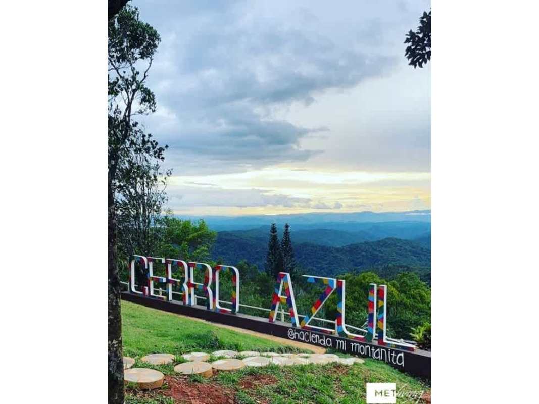 Covered rustic terrace with lounge chairs and dining table overlooking lush mountain landscape