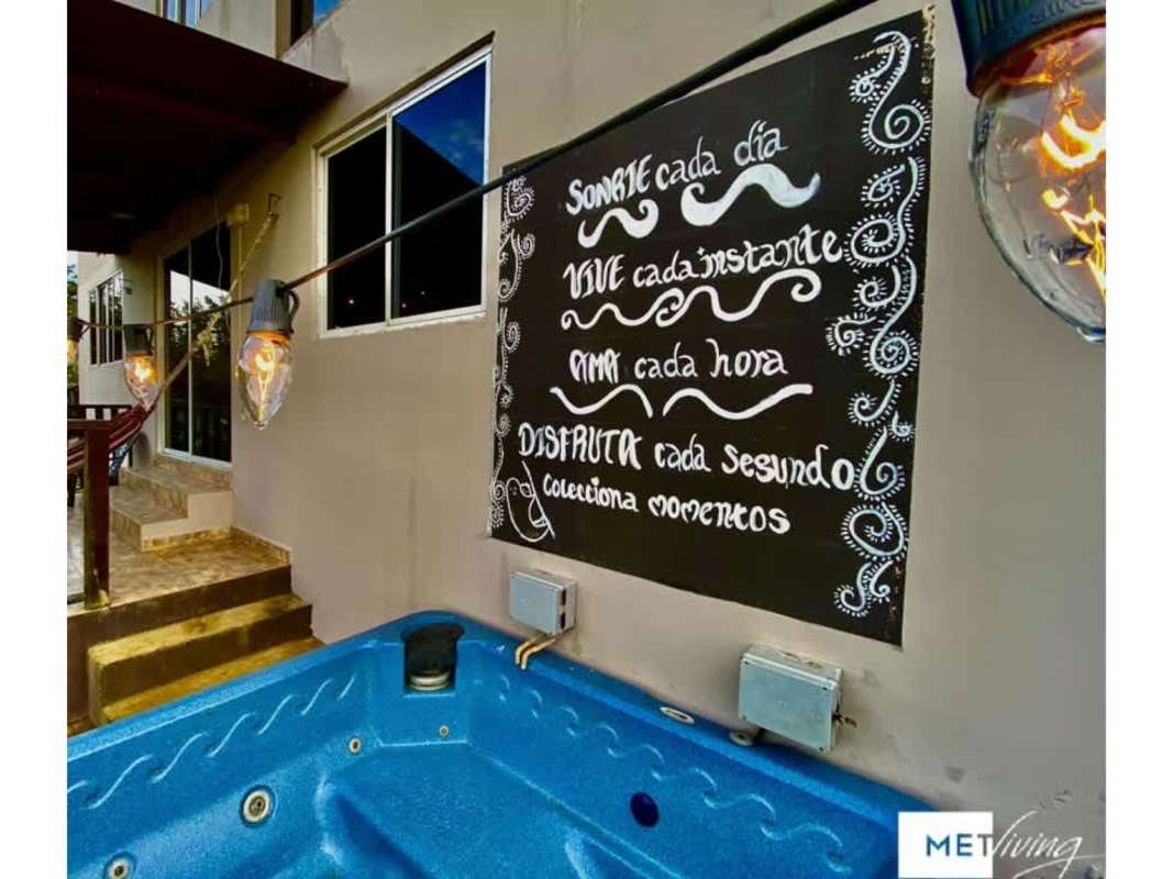 Rustic kitchen and living space with wood ceiling, sofa, and appliances in Cerro Azul eco cabin