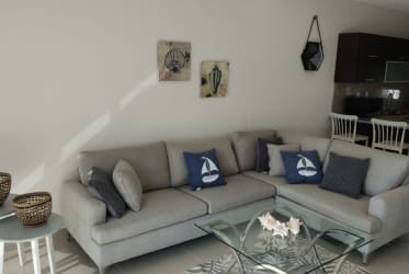 Coastal-style living room with sectional sofa, glass coffee table, open kitchen at PH Marina Golf Panama