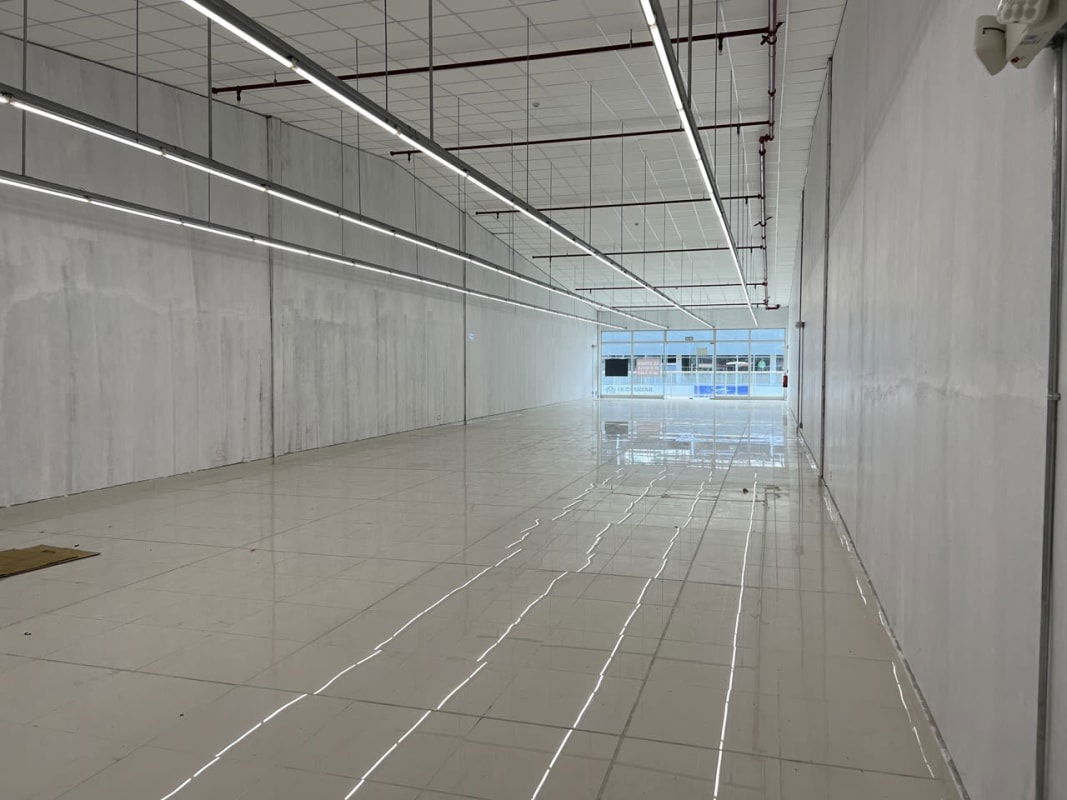 Empty commercial retail space with white tiled floor and open plan in Metro Park Plaza Costa Sur Panama