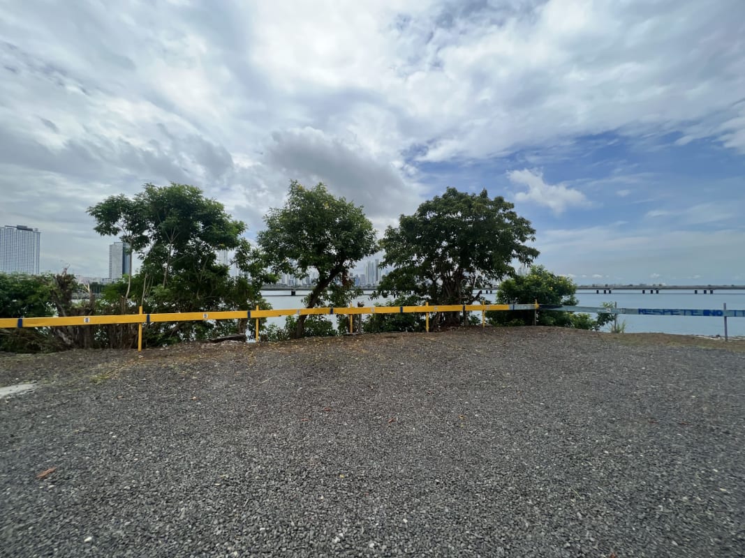 Waterfront gravel area with city skyline view and colonial Casco district Panama