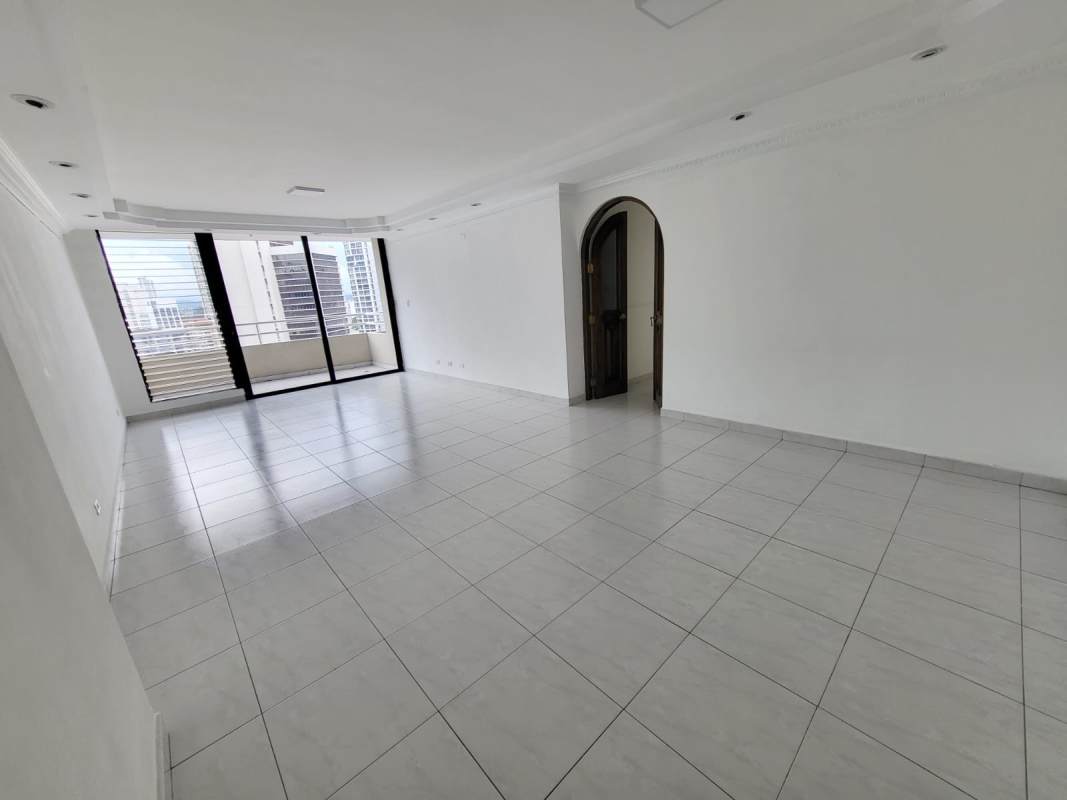 Bright ceramic-tiled living room with large sliding doors opening to city-view balcony PH Brisas Obarrio Panama City