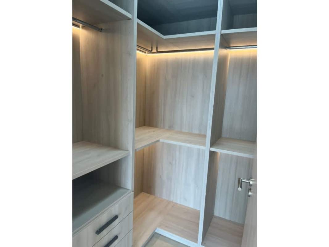 Walk-in closet with LED lighting and custom wood finishes at Ocean House Santa María Panama