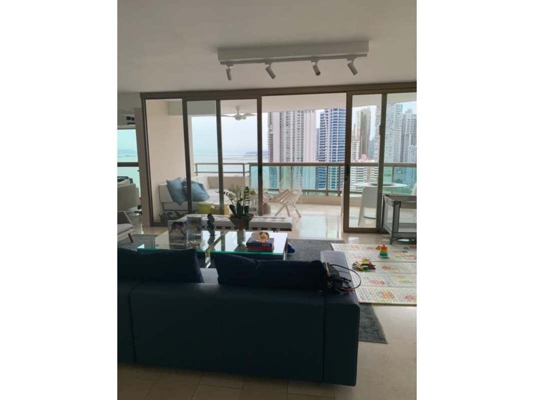 Dining room with glass top table, floor-to-ceiling windows overlooking Panama City skyline PH Ocean Park