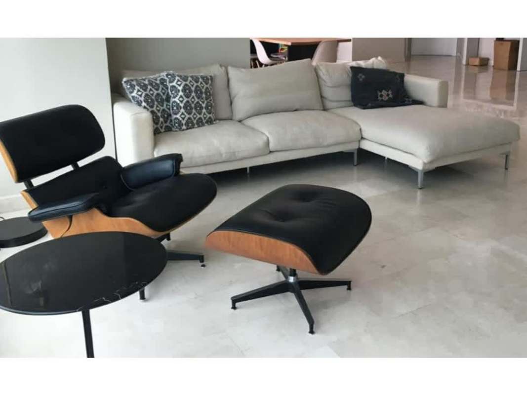 Modern living room with white sectional sofa, black lounge chair, marble flooring in PH Ocean Park Punta Pacifica Panama