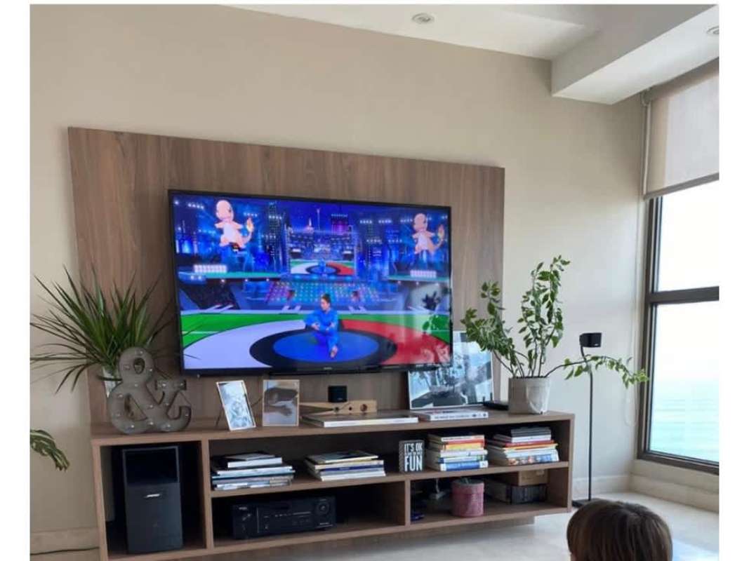 Modern living room with wall-mounted TV, wooden unit, large ocean view window in PH Ocean Park Punta Pacifica Panama
