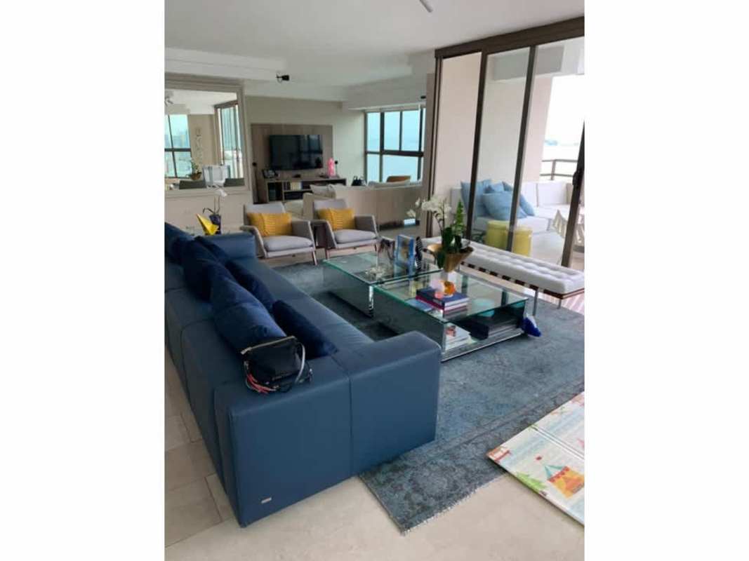 Contemporary living room with blue sectional sofa, balcony access with city and ocean views PH Ocean Park Panama