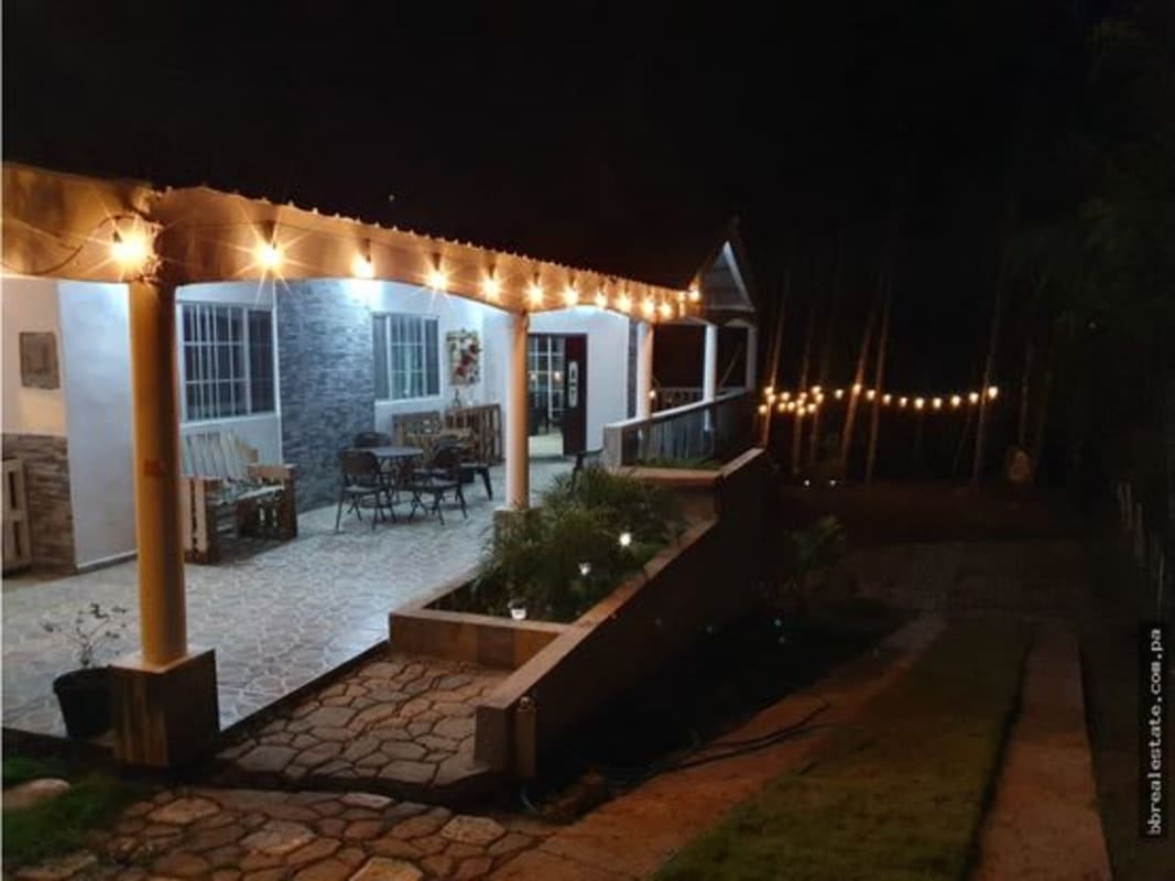 Rustic covered porch with lighting at night in Altos de Cerro Azul mountain home Pacora Panama