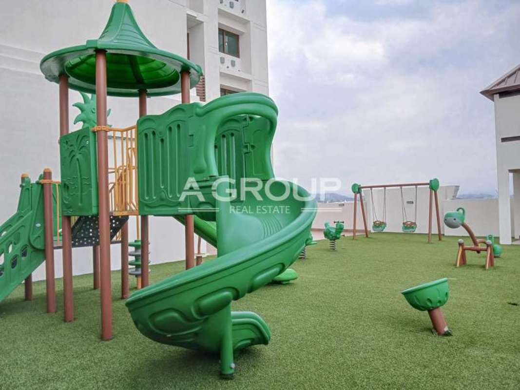 Rooftop children's playground with artificial turf and slides in The Colonial Santa Maria Panama City