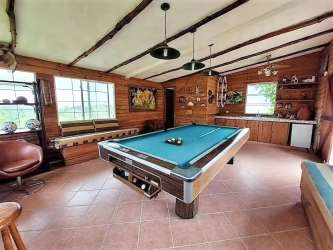 Entertainment room with pool table, wooden paneling and bar area in countryside house El Valle Panama