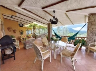 Covered outdoor terrace with scenic mountain backdrop hammock and dining in Los Llanitos Panama