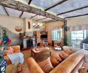 Rustic family room with fireplace, wood ceiling beams at countryside estate El Valle Panama
