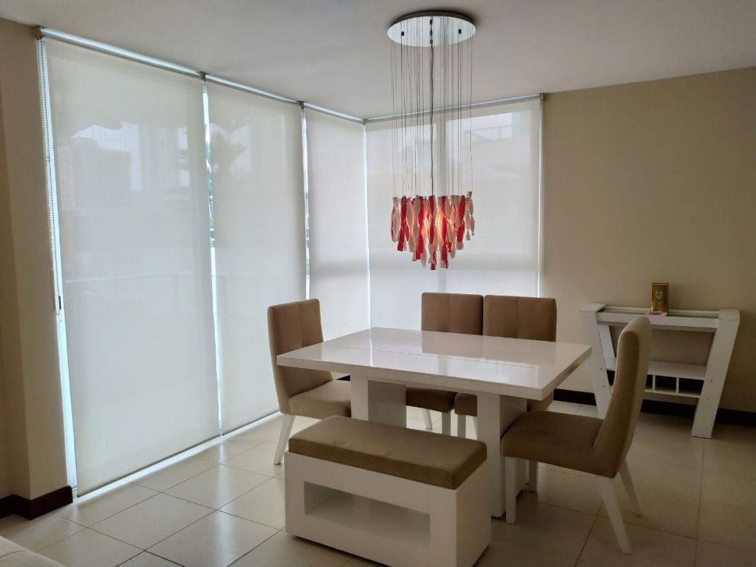 Contemporary dining room with chandelier and large window PH Costa del Este Tower Panama City