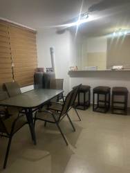 Dining area with glass table beside kitchen breakfast bar in beach house Coronado Panama