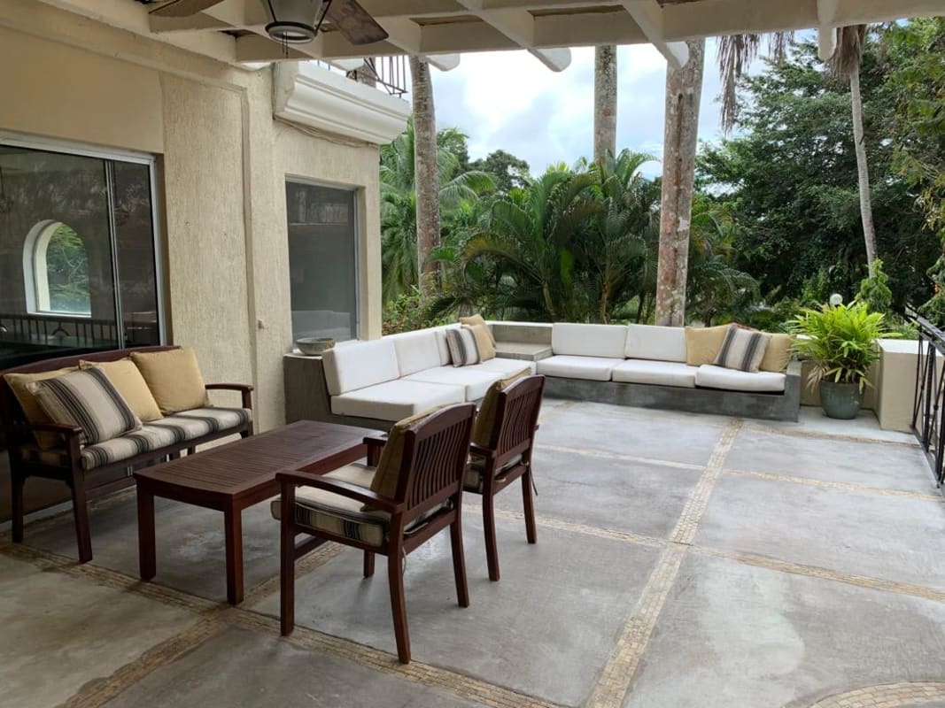 Covered patio with wooden beams, seating area and pergola in luxury house for rent Albrook Panama City