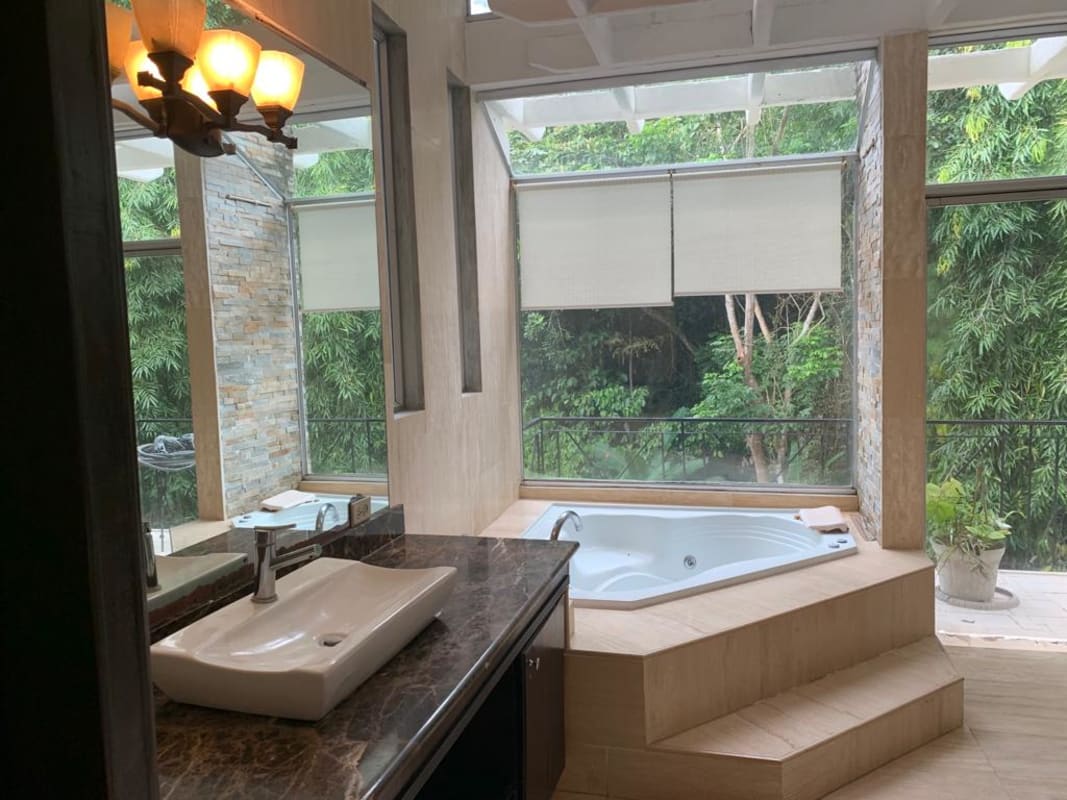 Spacious master bedroom with private balcony jacuzzi tub and forest views in Albrook rental home Panama