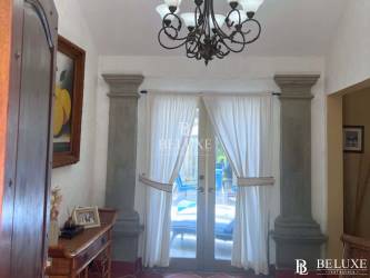 Swimming pool surrounded by lush garden beach house Buenaventura resort Panama