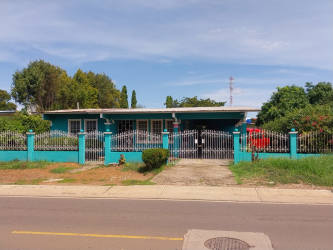 Turquoise house with metal fence, driveway and large front yard in Barriada San Roque Aguadulce Panama