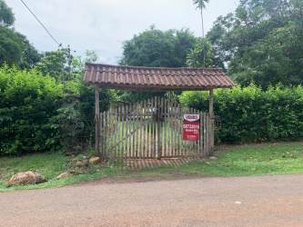 Caretaker house with front porch surrounded by garden trees at farm in Villa Rosario Capira