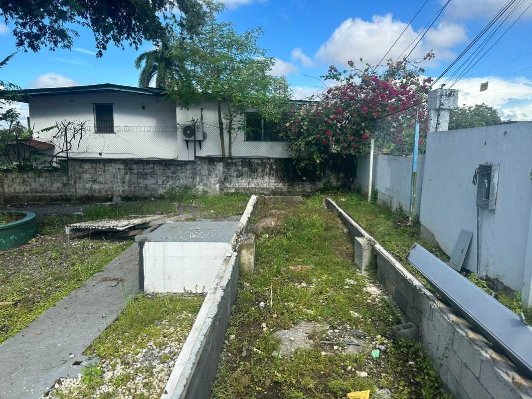 Vacant fenced commercial lot with foundation remnants on busy corner in Parque Lefevre Panama City