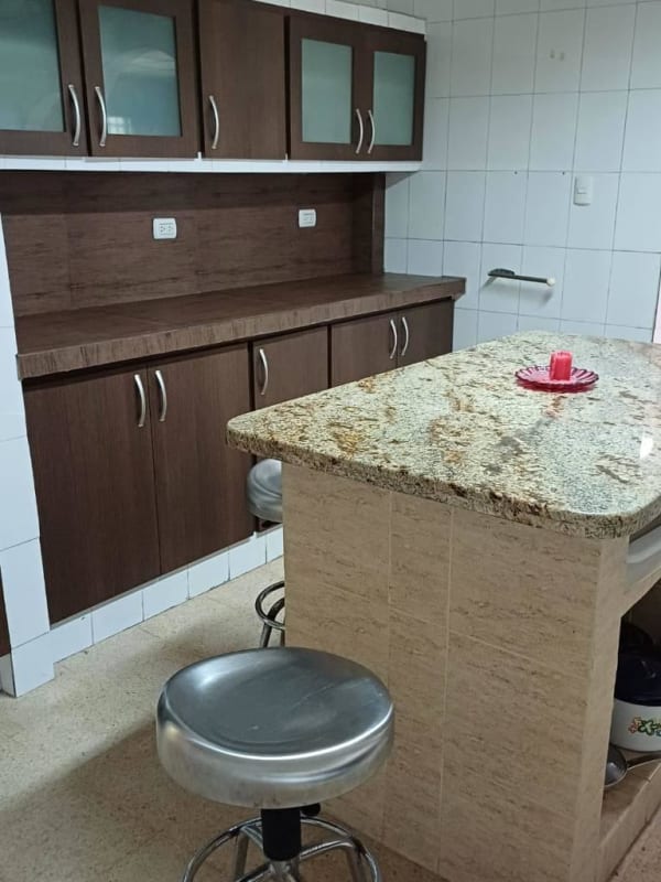 Shower area featuring beige tiles, small window, mosaic border in Panama home