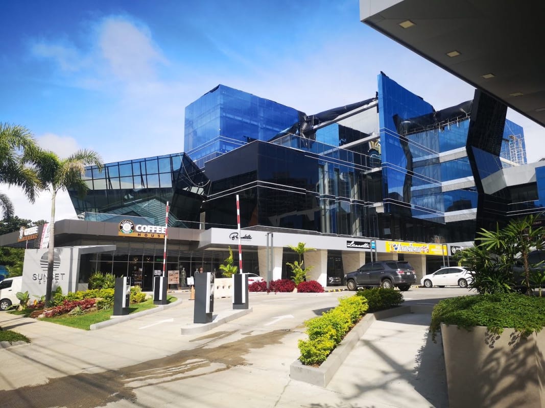 Contemporary commercial plaza Sunset Strip glass facade reflective windows Via Israel Panama City