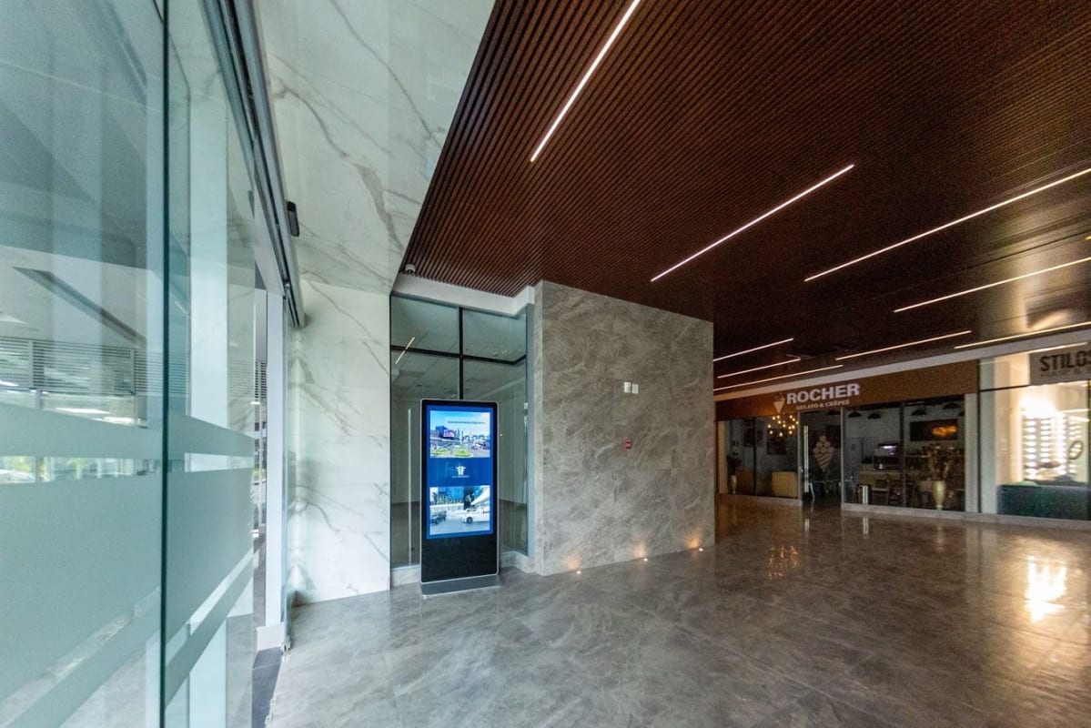 Interior hallway with glass office dividers polished tile floors modern lighting Sunset Strip Plaza Panama