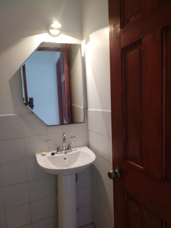 Compact bathroom with pedestal sink octagonal mirror PH La Cresta Panama